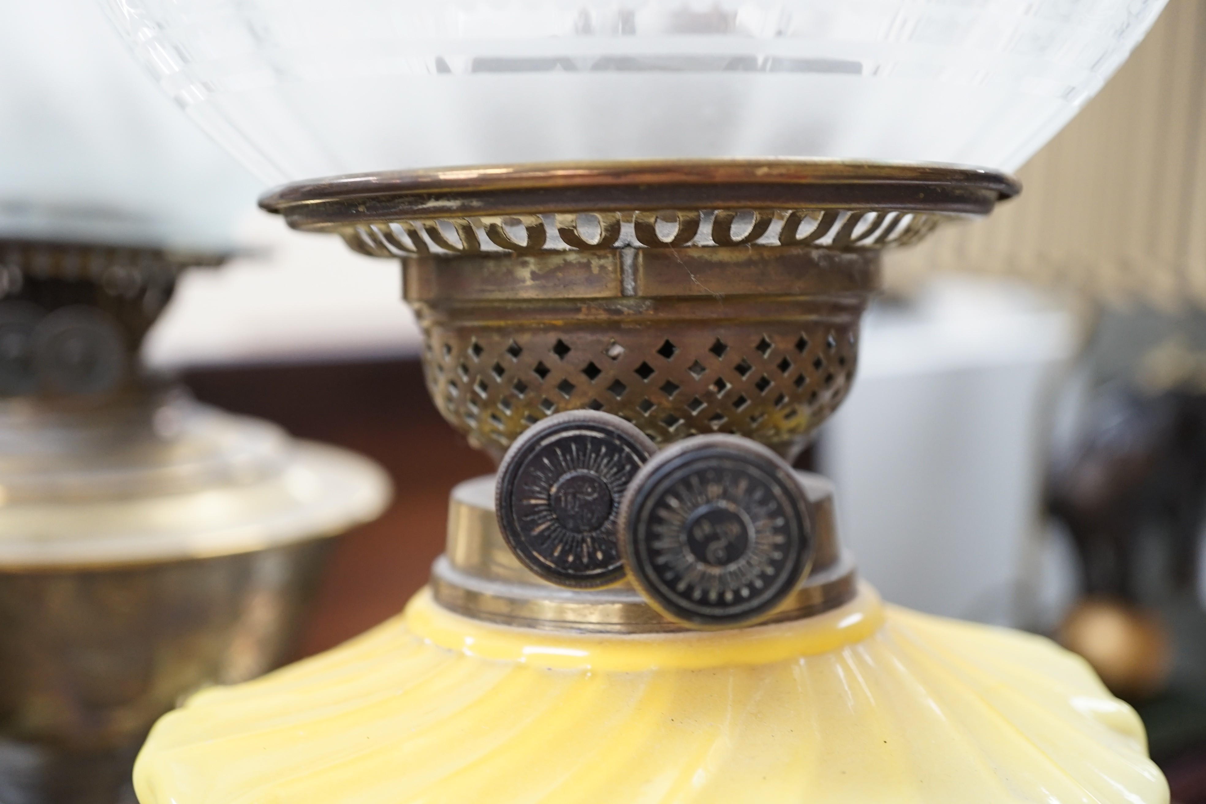 A brass and glass oil lamp and another brass oil lamp, both with shades, tallest 67cms high